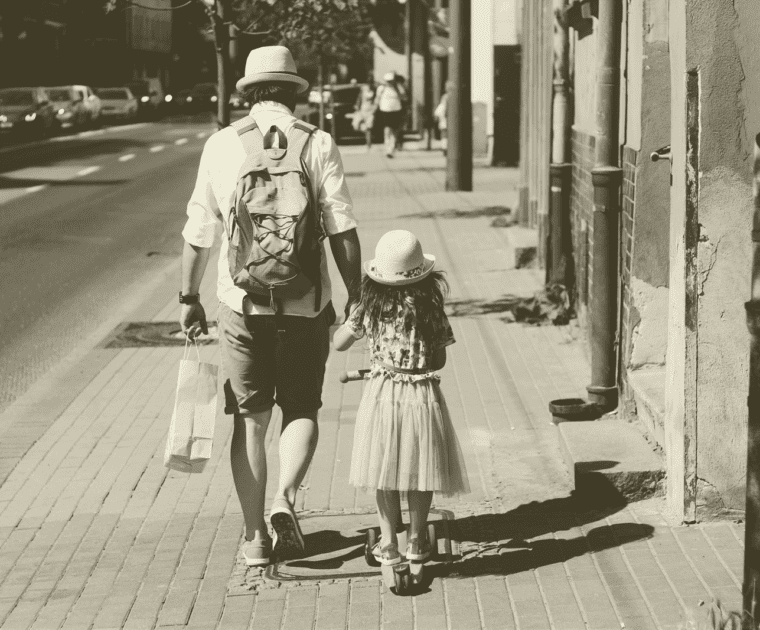 Father and daughter taking a walk down the city street together.