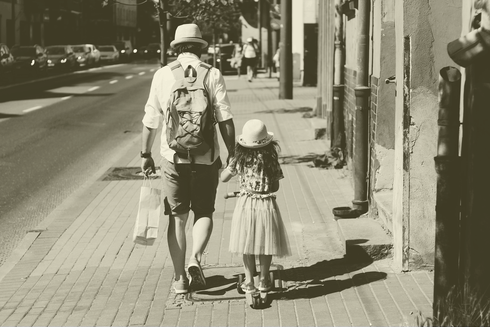 Father and daughter taking a walk down the city street together.